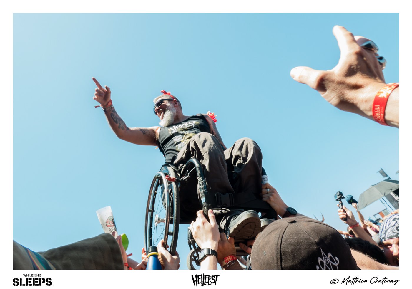 Slam en fauteuil roulant porté par la foule sous le ciel bleu